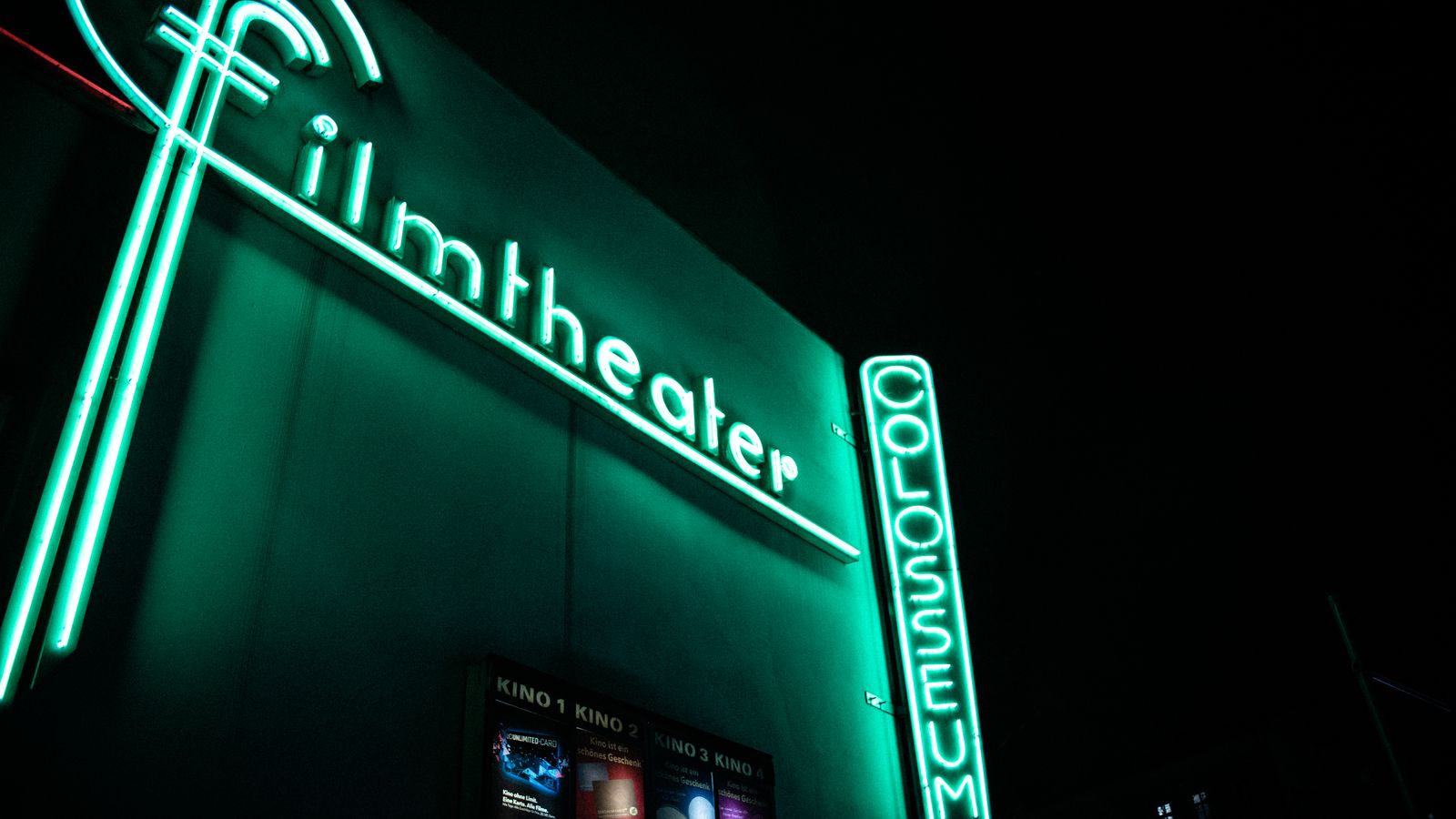 Pink neon wall sign glowing above a decorated shelf in a living room