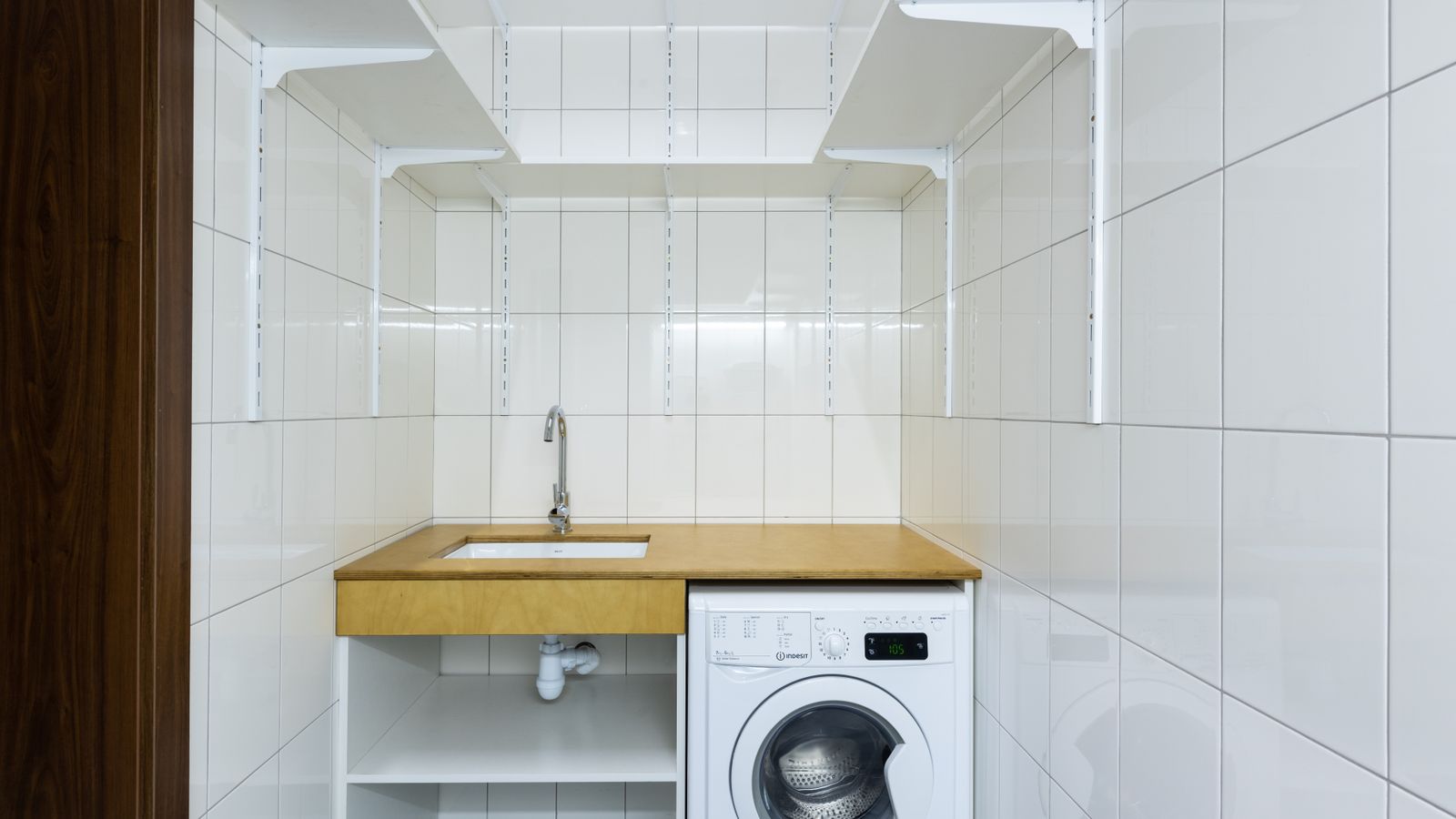Organized laundry room shelving with folded towels and storage baskets