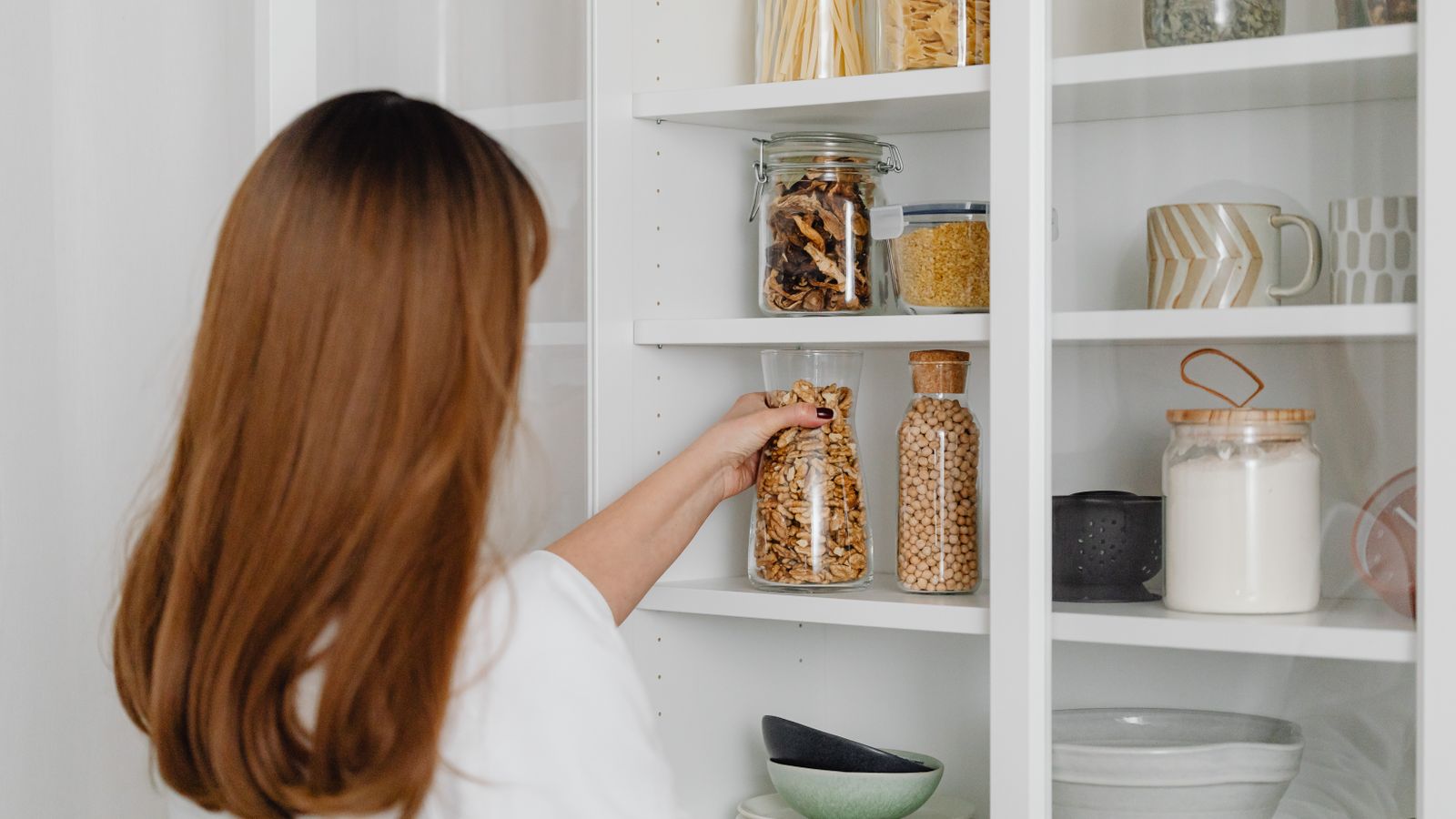 Organized under-sink cabinet with pull-out storage bins and cleaning supplies neatly arranged