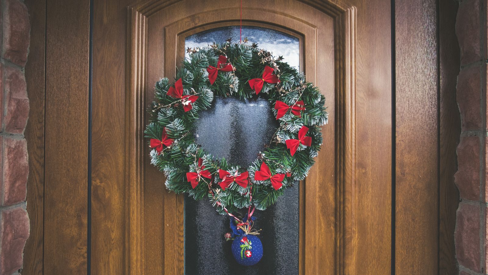 A decorative wreath hanging on a front door as a seasonal wall accent